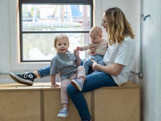 Stephanie sitting by a window with her two young daughters