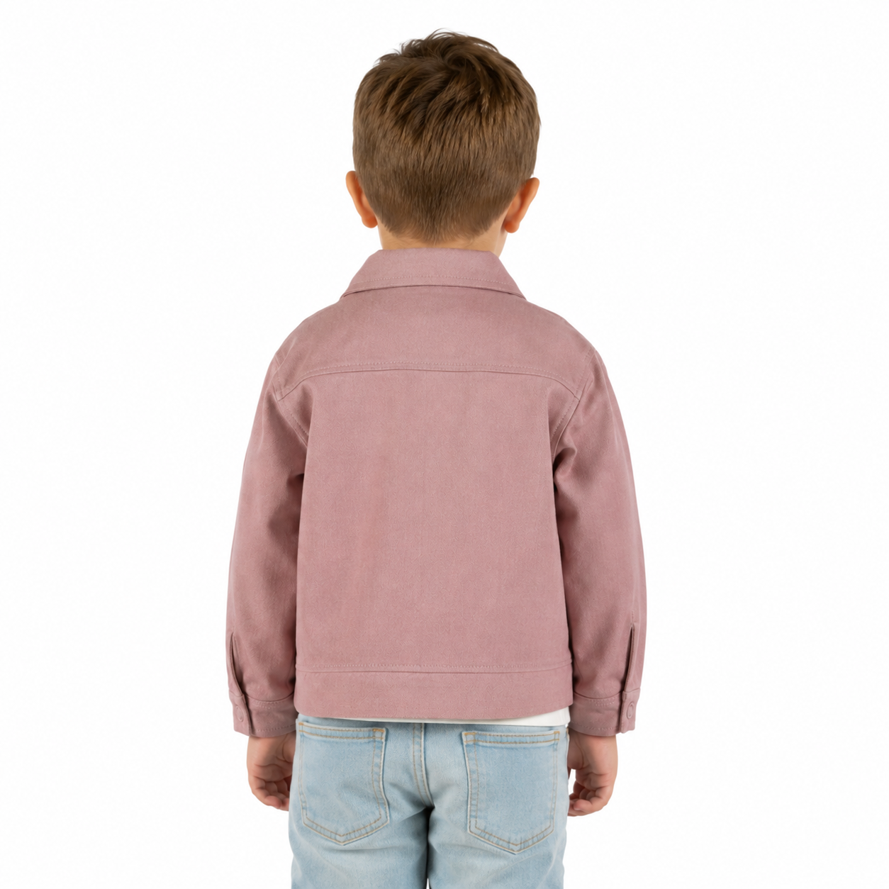 A young boy viewed from behind wearing a dusty rose pink jacket and light blue jeans, set against a plain white background.