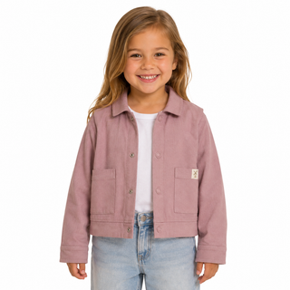 A young girl smiling and wearing a dusty pink shacket over a white t-shirt and light blue jeans, photographed against a solid white background.