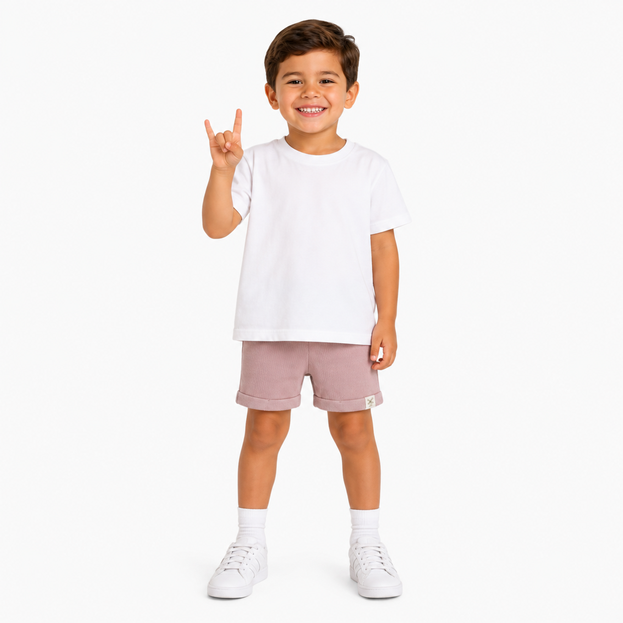 A young boy modeling a white short-sleeve t-shirt and dusty rose pink shorts against a clean white background.