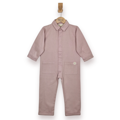 A dusty pink child's jumpsuit hanging on a wooden hanger against a plain white background. The boilersuit features a button-up front, a shirt collar, and two front patch pockets.