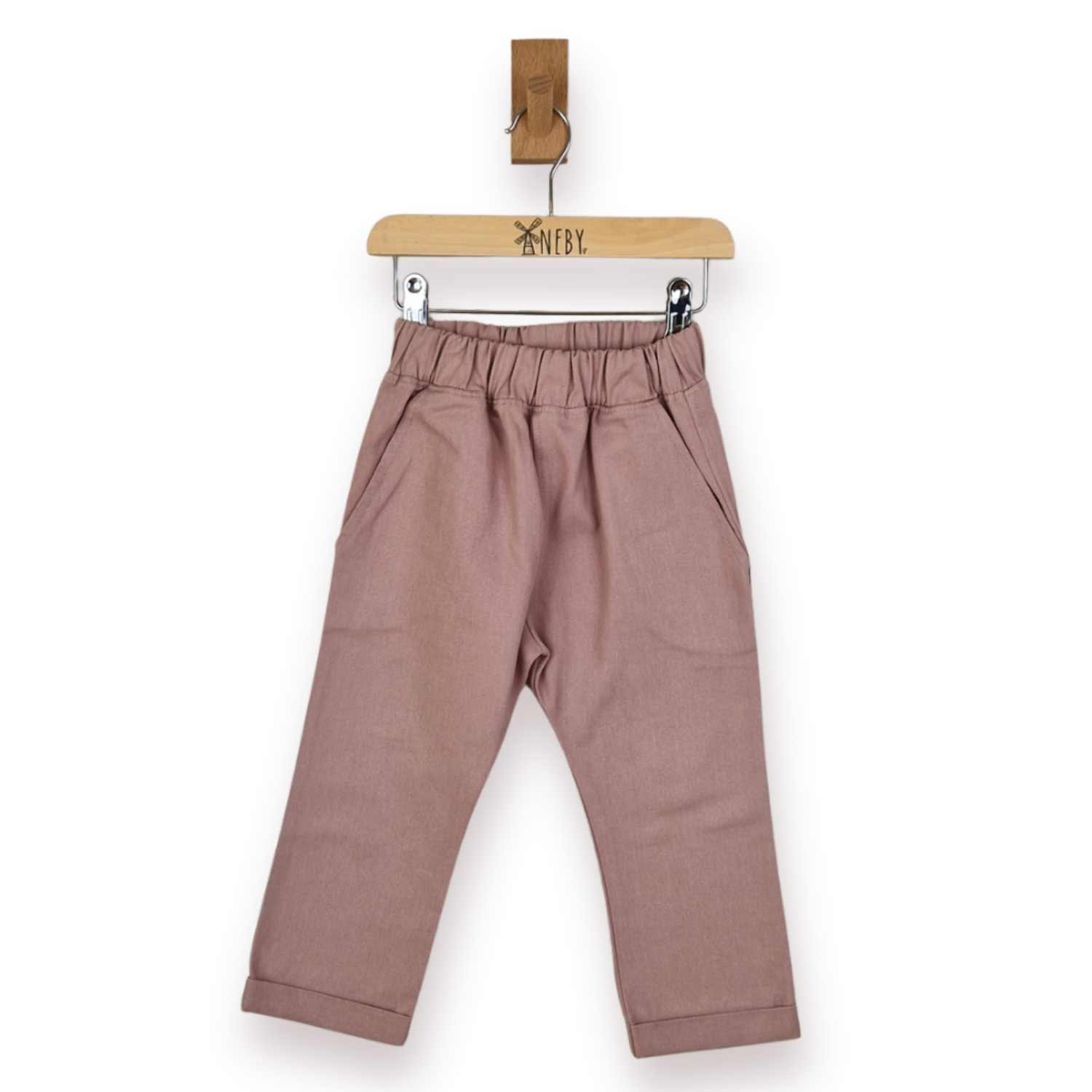 A pair of dusty rose toddler pants with an elastic waistband and side pockets, hanging from a wooden hanger, against a plain white background.