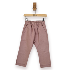 A pair of dusty rose toddler pants with an elastic waistband and side pockets, hanging from a wooden hanger, against a plain white background.