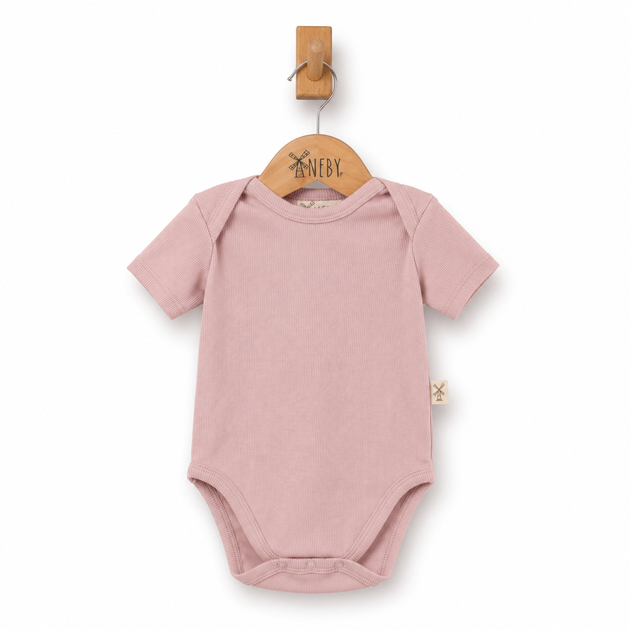 A dusty pink short-sleeve baby bodysuit hanging on a wooden hanger with a wooden peg, against a plain white background.