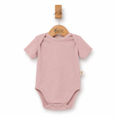 A dusty pink short-sleeve baby bodysuit hanging on a wooden hanger with a wooden peg, against a plain white background.