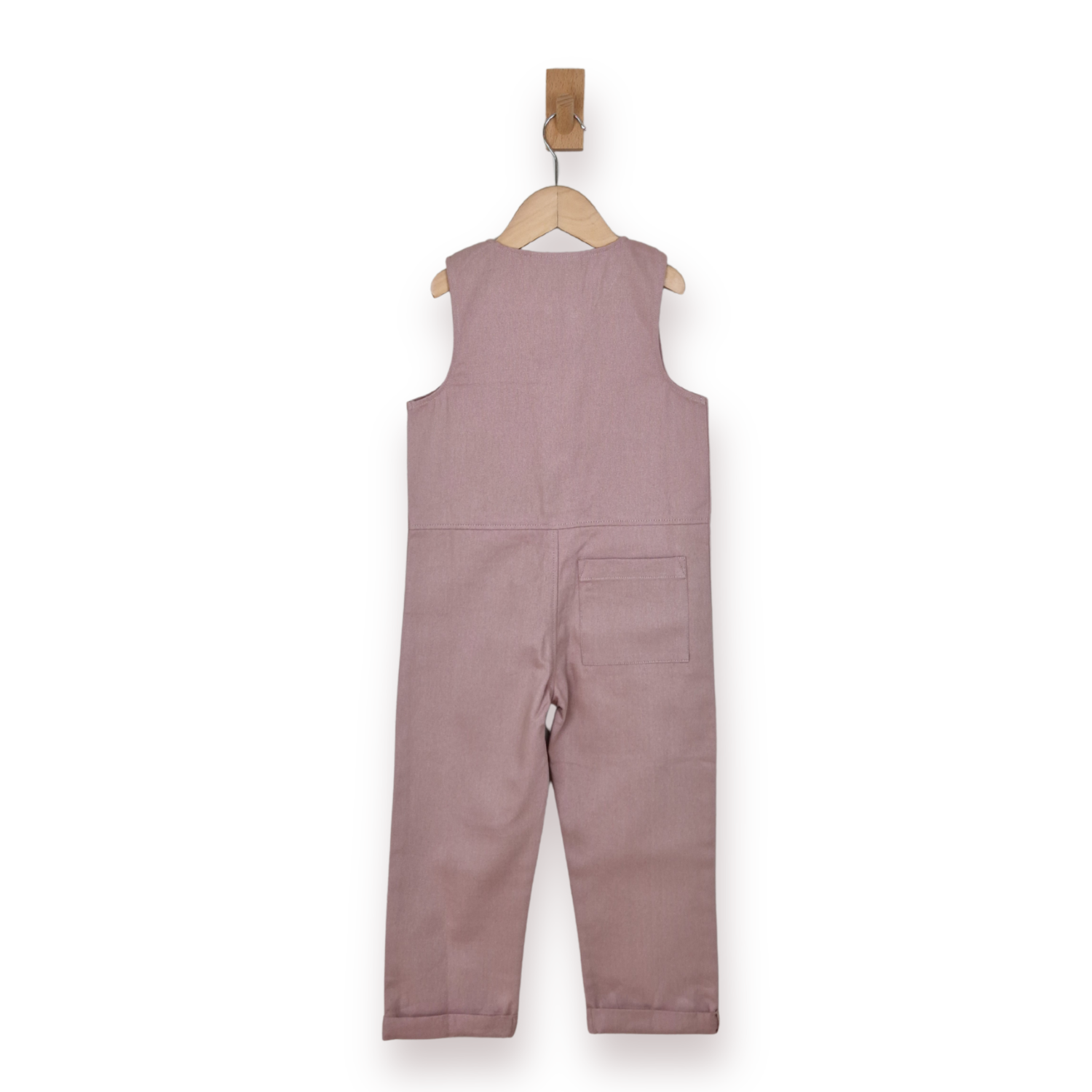 A sleeveless dusty rose jumpsuit hanging from a wooden hanger on a white background.