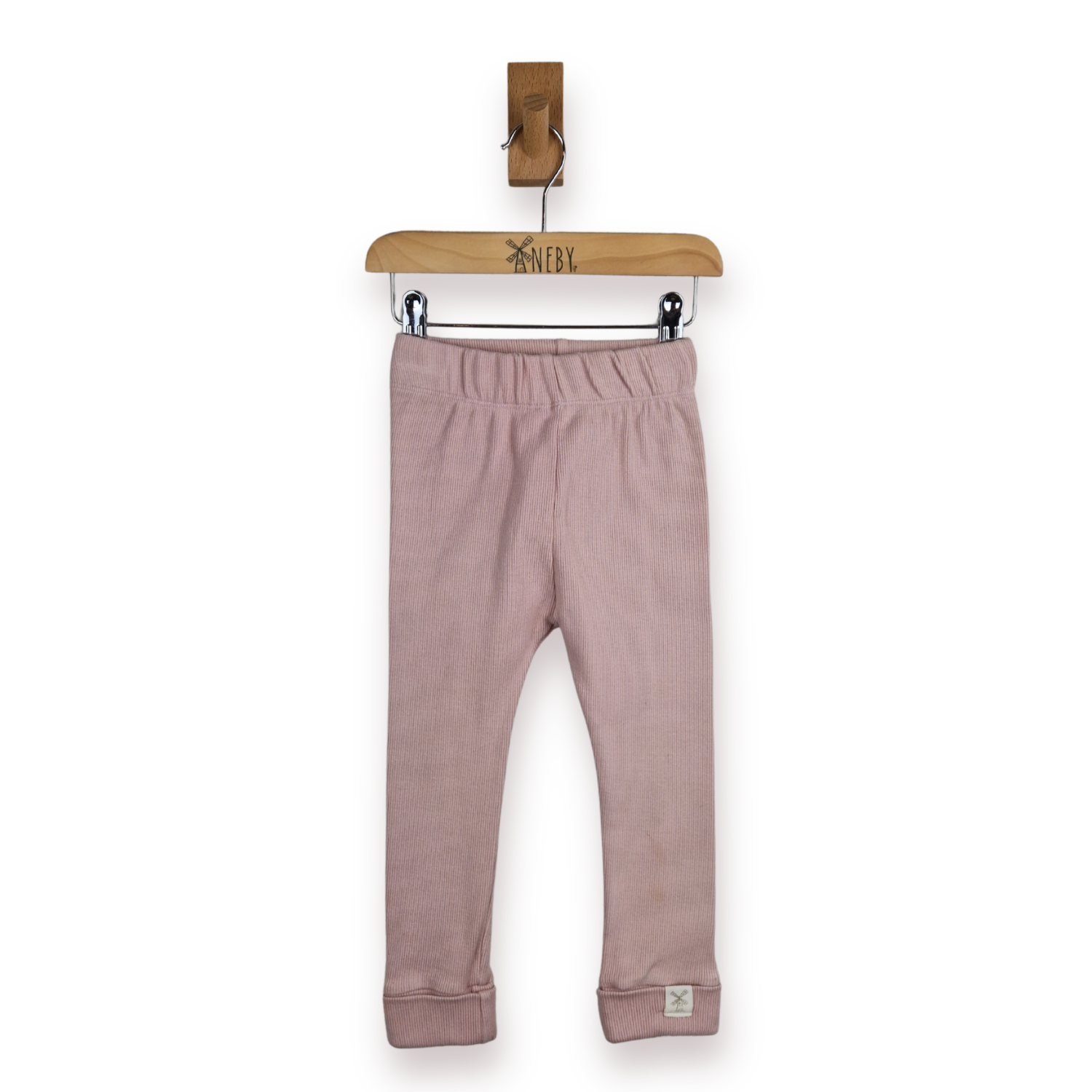 A pair of pink leggings for kids and toddlers, hanging from a wooden hanger on a white background.