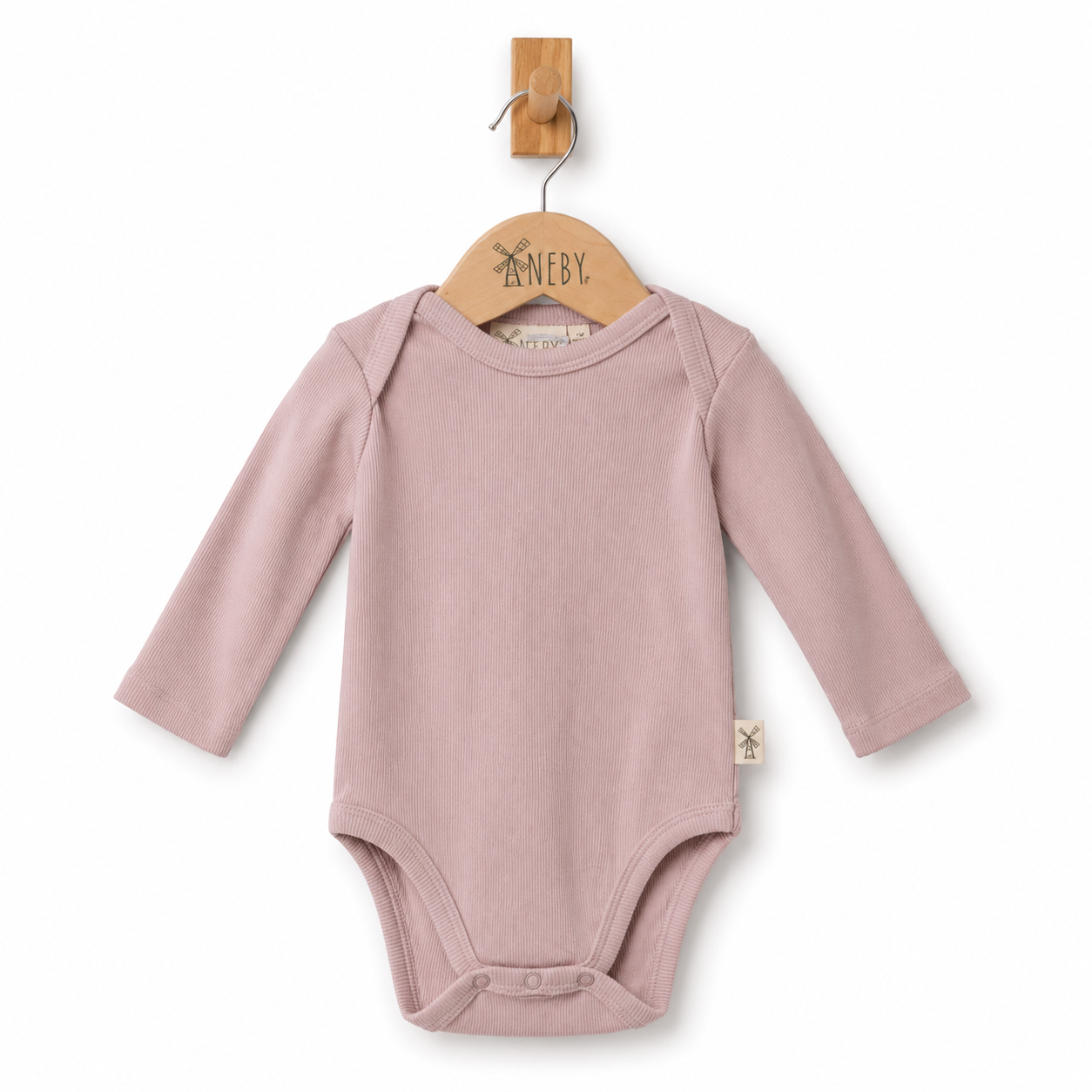 A dusty pink long-sleeve baby bodysuit hanging on a wooden hanger with the brand name 'ANEBY' visible, set against a plain white background.
