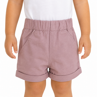 A child wearing pink shorts with an elastic waistband, paired with a white top, shown from the chest down on a white background.