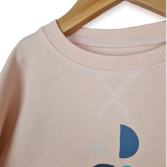 Pink sweatshirt with colourful design on a hanger