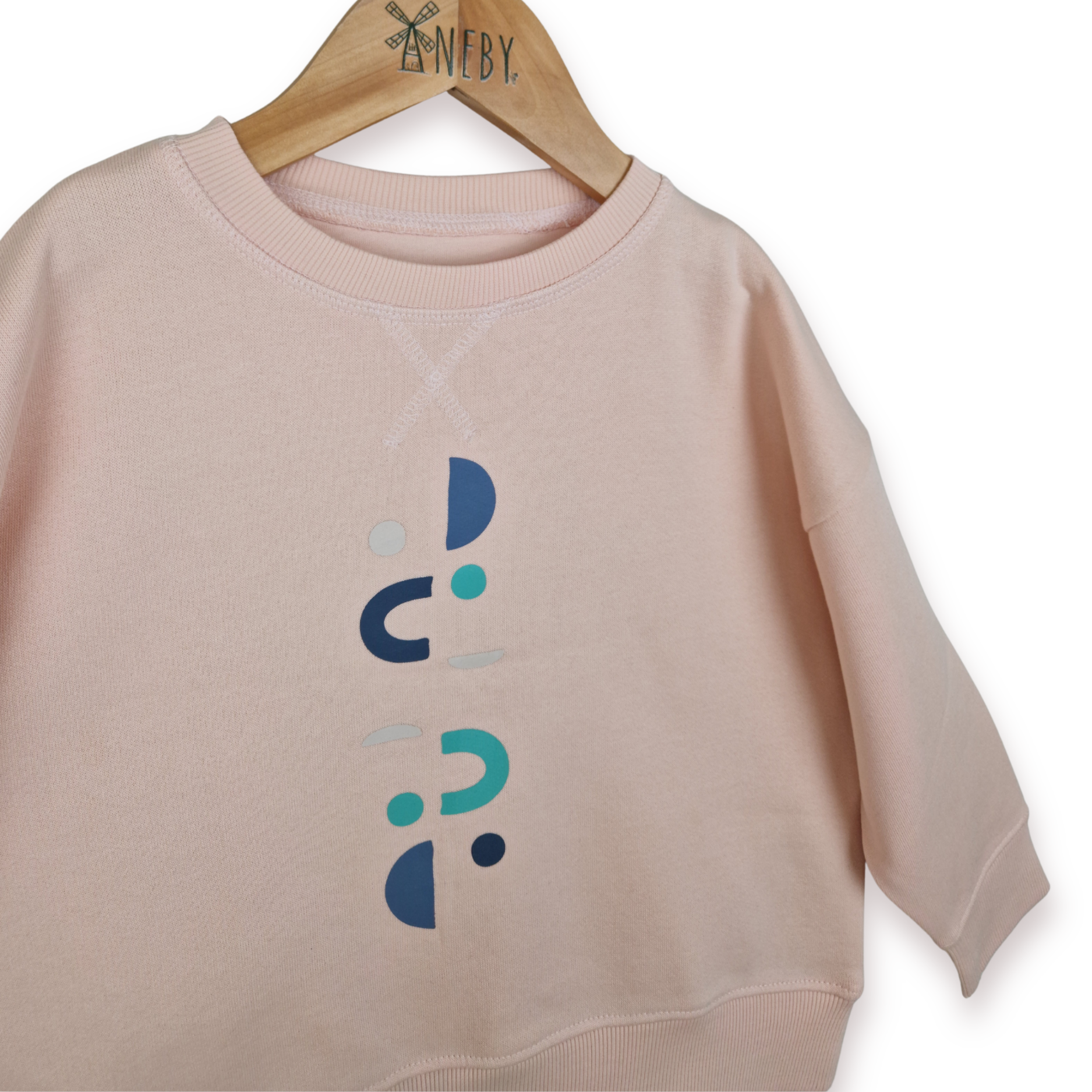 Pink sweatshirt with a blue and green abstract design on a hanger with white background.