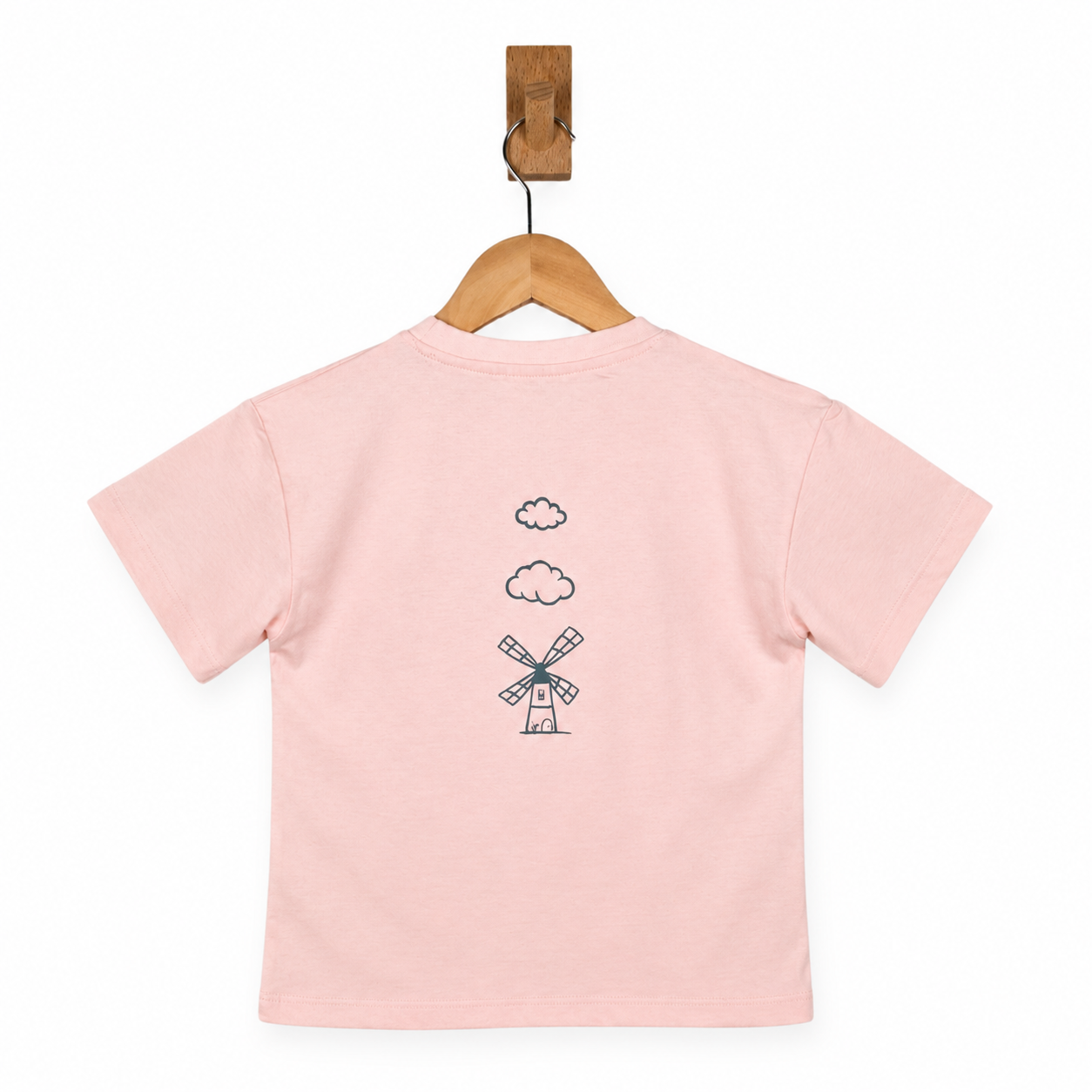 Pink t-shirt with a windmill design on a wooden hanger against a white background