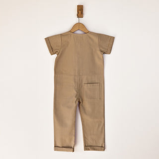 Back of Oat beige jumpsuit with patch pocket and rolled hem