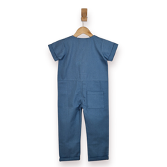 A kids blue short-sleeve jumpsuit shown from the back, hanging on a wooden hanger against a plain white background.
