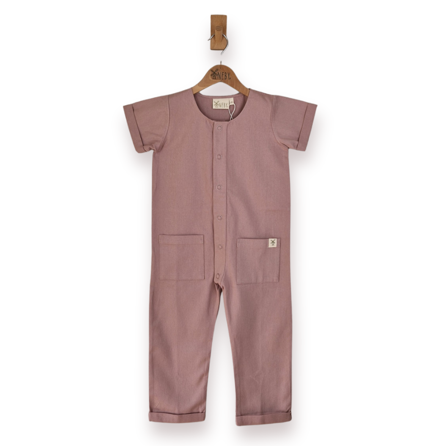 Front image of a pink short-sleeve one-piece jumpsuit hanging on a wooden hanger against a plain white background.