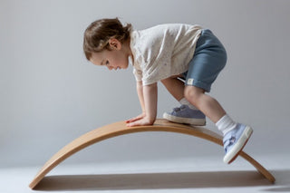 Aneby model wearing speckled effect t-shirt whilst climbing over a wooden wobble board