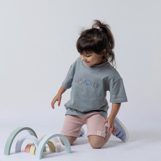 Grey-blue short sleeved t-shirt being modelling by a young girl with a quirky camping design