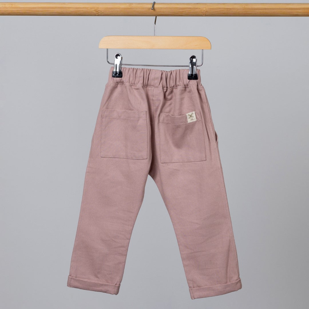 Dusty Pink twill smart trousers hanging on a rail