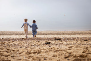 Aneby models holding hands walking towards the sea 
