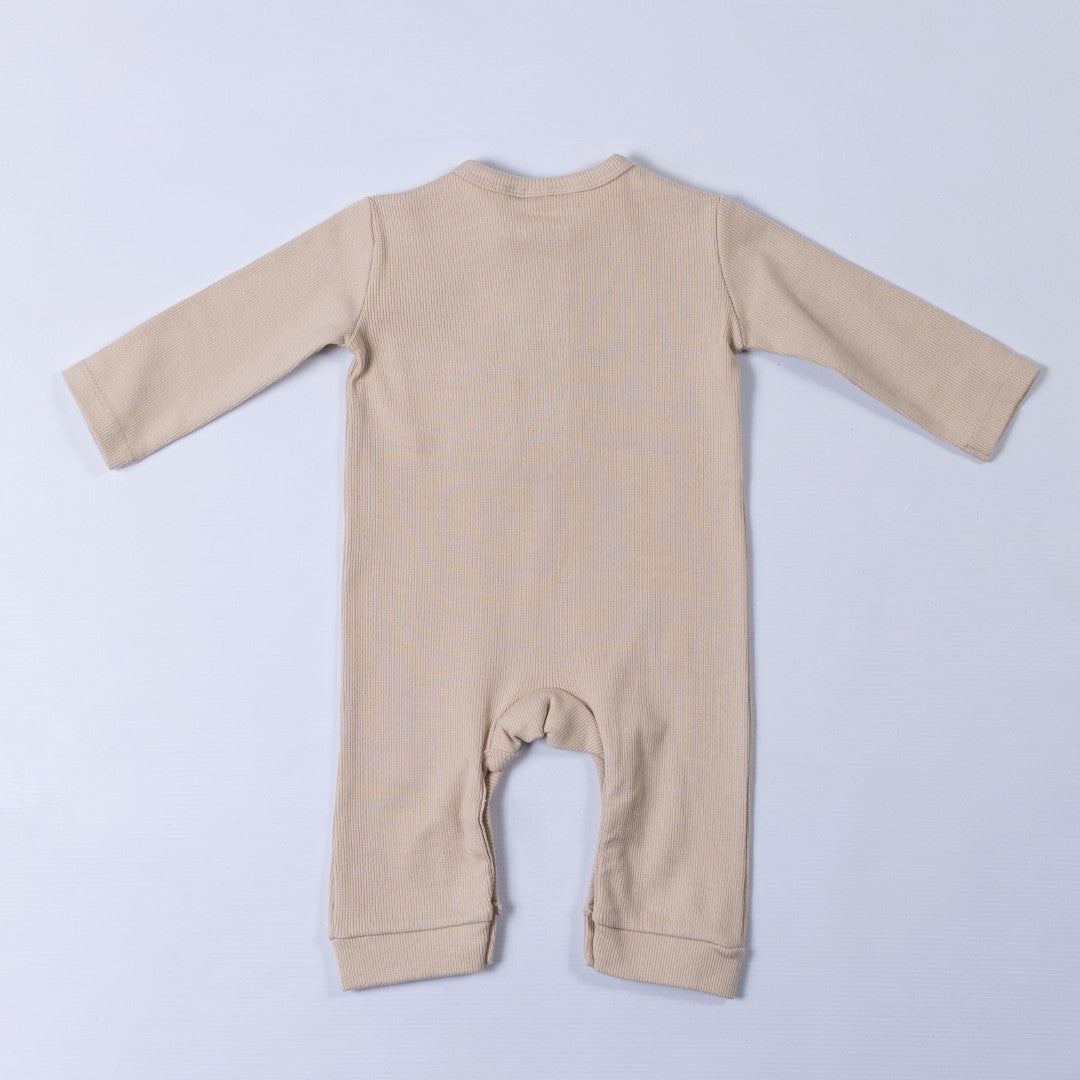 Beige ribbed cotton baby jumpsuit laid flat on a neutral background, showing the back design.