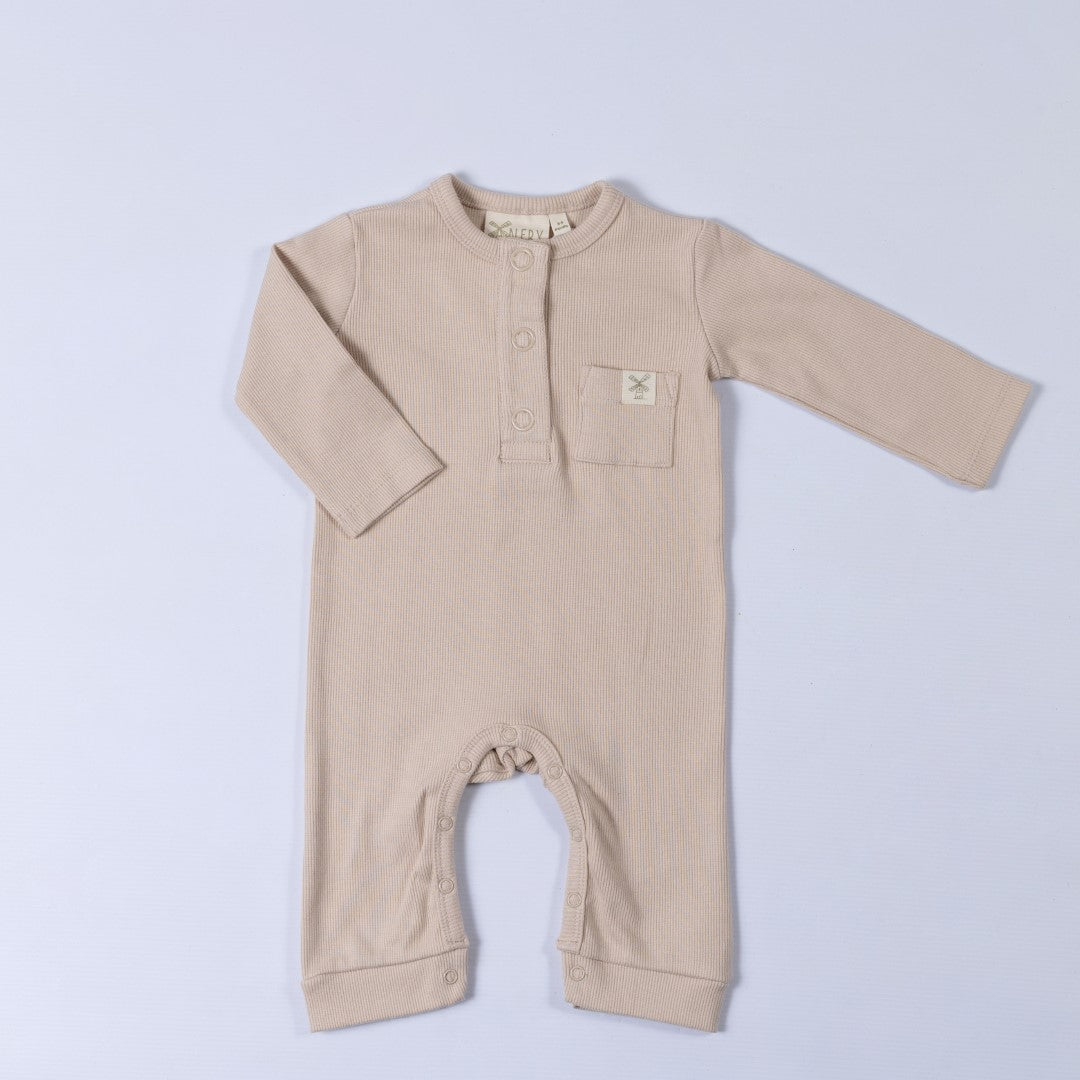 Beige ribbed cotton baby jumpsuit laid flat on a neutral background, showing the front design.