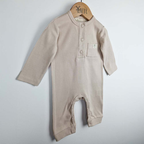 Beige ribbed cotton baby jumpsuit laid flat on a neutral background, showing the front design.