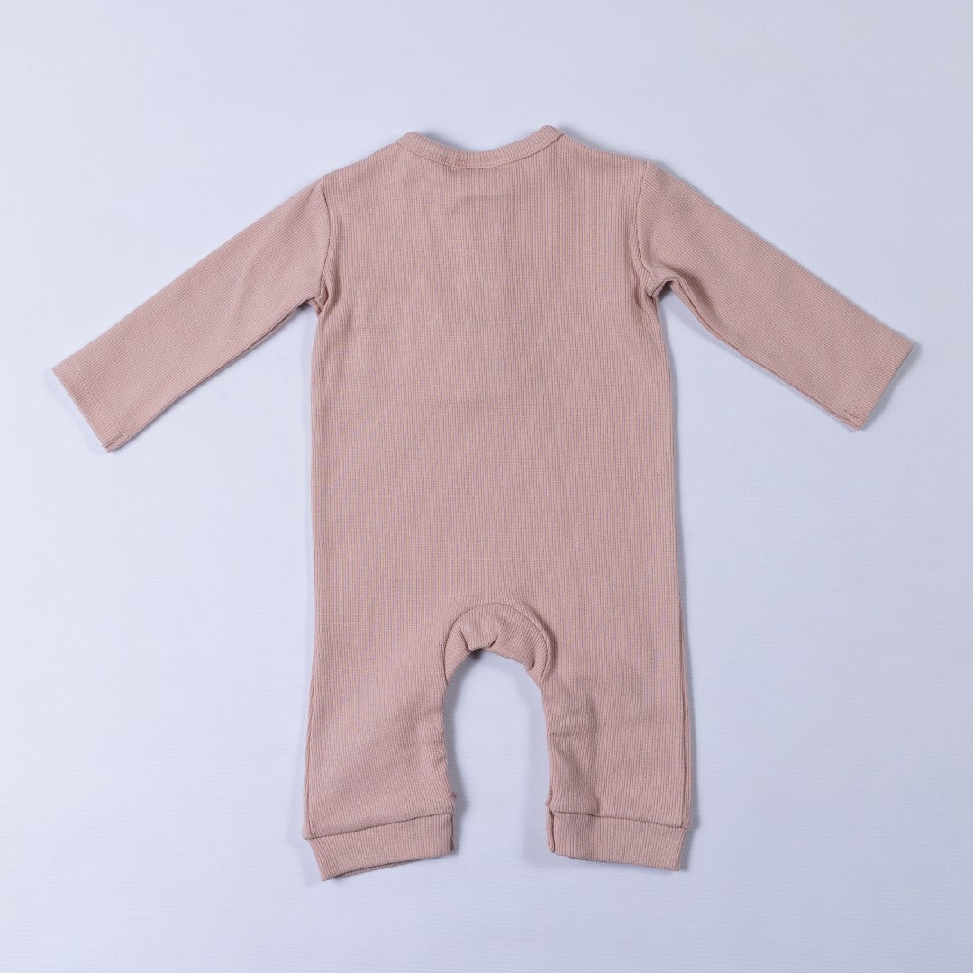 Dusty pink ribbed cotton baby jumpsuit laid flat on a neutral background, showing the back design.