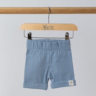 Front view of blue ribbed organic cotton kids shorts hanging on a wooden hanger, with neutral background.