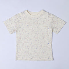 Flat lay of an ecru children's paint splat t-shirt, front view. The t-shirt features a scattered paint splatter pattern in soft pastel and earthy tones, adding a creative and playful look.