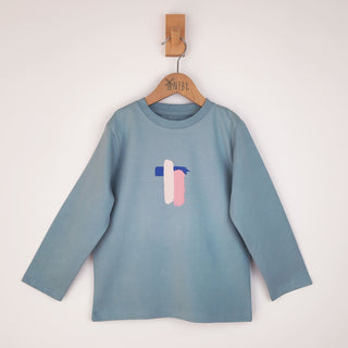 Flat lay of a kids' long sleeve artist t-shirt with a brushstroke pattern in pink, blue, and white. The abstract design is spread across the entire front, creating a bold and expressive artistic look.
