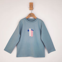 Flat lay of a kids' long sleeve artist t-shirt with a brushstroke pattern in pink, blue, and white. The abstract design is spread across the entire front, creating a bold and expressive artistic look.