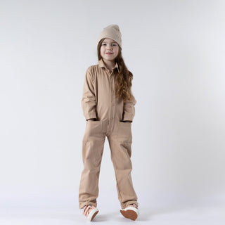 Children's oat-coloured boilersuit, front view, with a relaxed fit and button-up closure.