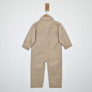 Back view of an oat-coloured twill kids boilersuit, showing its relaxed fit and stitching details.