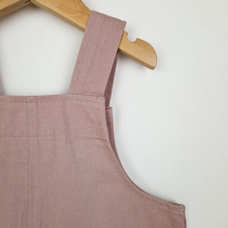 Back close up view of dusty pink kids' dungarees with patch pockets, designed for everyday play.