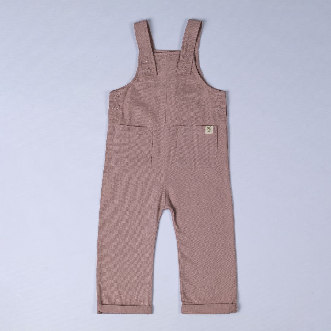 Front view of dusty pink kids' dungarees with patch pockets, a soft and stylish choice.