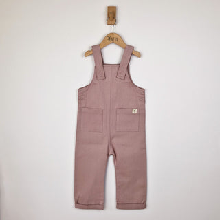 Front view of dusty pink kids' dungarees with patch pockets, a soft and stylish choice.