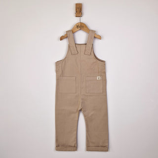 Front view of oat-coloured kids' dungarees with patch pockets, designed for comfort and style.