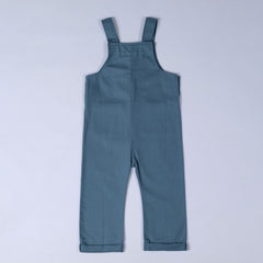 Back view of slate blue kids' dungarees with patch pockets, showcasing adjustable straps.