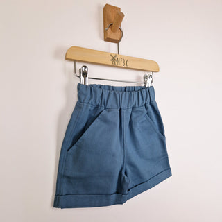 Slate blue elasticated chino shorts hanging, front view, neutral background.