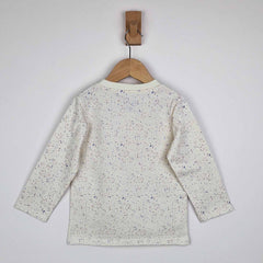 The back of a kids long sleeve ecru t-shirt on a wooden hanger showing close-up detail of the speckled print and relaxed fit on a neutral background. 