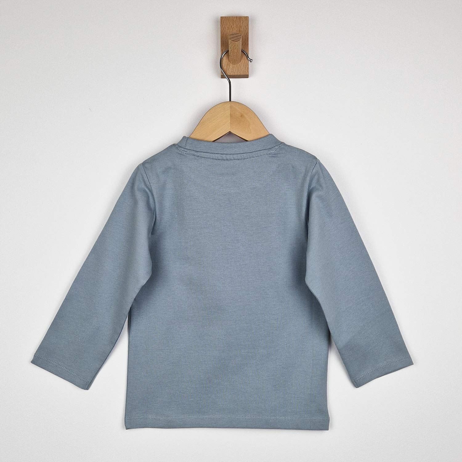 Back view on wooden hanger of kids long sleeve tshirt with stars showing plain grey finish with neat back yoke detail, relaxed drop shoulder fit and neat hem stitching.