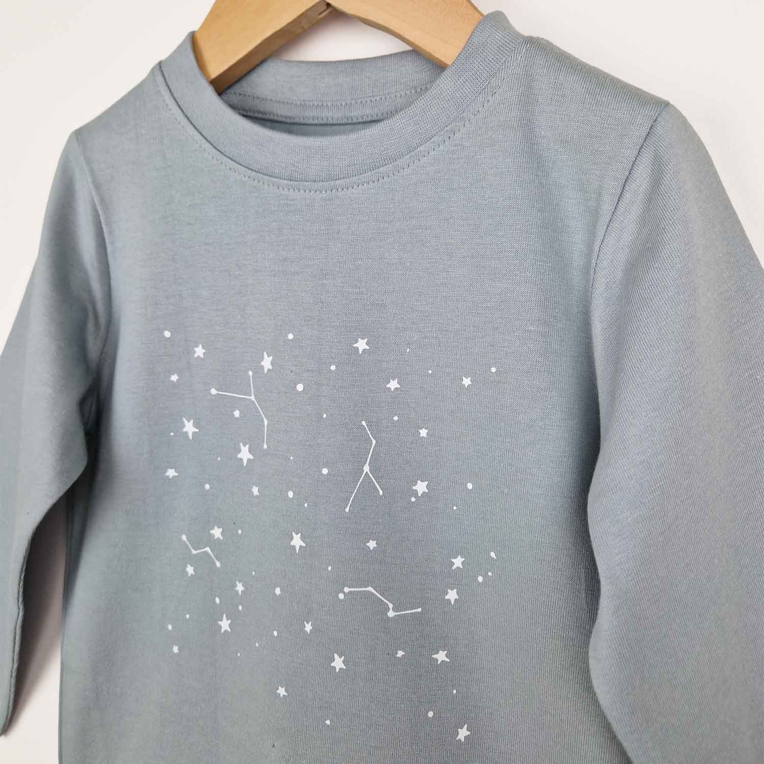 Close up photos of kids long sleeve tshirt with stars showing cute constellation star print in white and neat collar finish with edge stitching. 