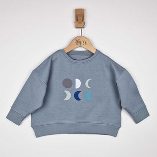Flat lay of a grey kids moon sweatshirt, featuring six moons printed on the front, displayed against a neutral background.
