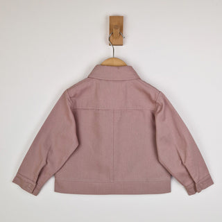 Back view of a dusty pink kids' organic cotton shacket, showcasing the relaxed fit and high-quality finish with yoke and centre back seam, waistband and button up cuffs.