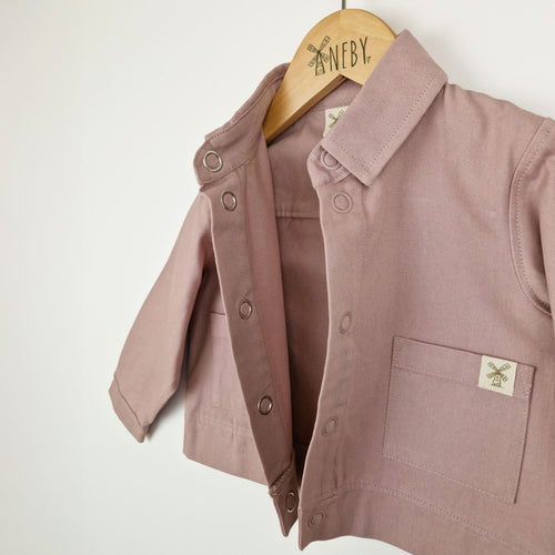Front view of a dusty pink kids' organic cotton shacket, crafted from soft organic cotton twill.