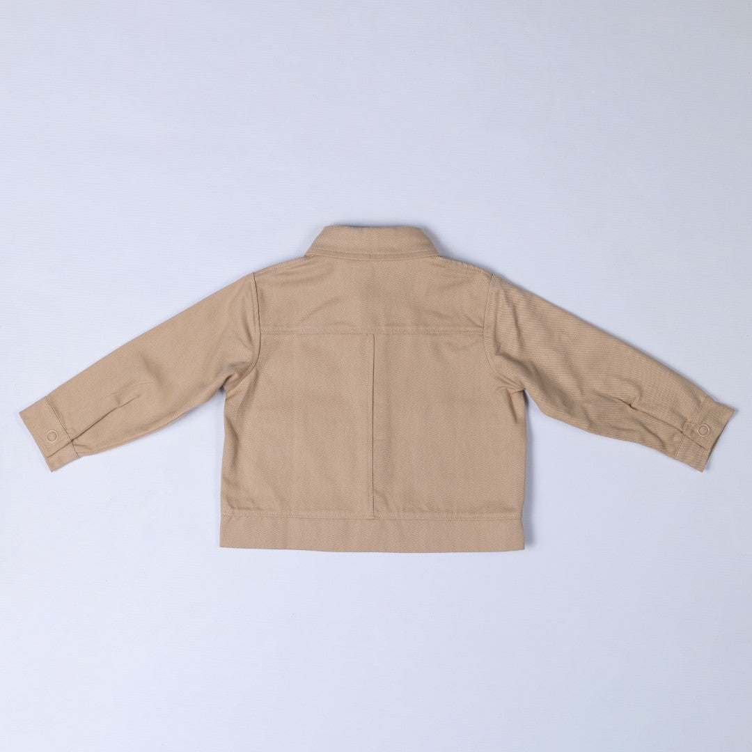 Back view of an oat-coloured kids' organic cotton shacket, featuring a timeless and minimalistic design.