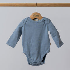 Slate blue ribbed bodysuit with long sleeves for babies, displayed on a hanger against a neutral background.